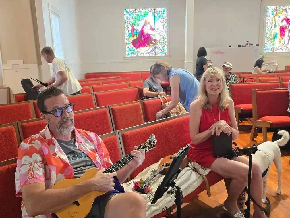 Two players in the pews with a small white dog