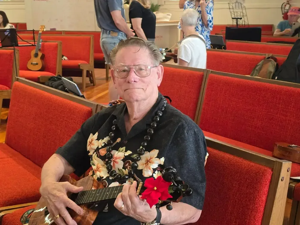 A player wearing a flower lei, mid-song