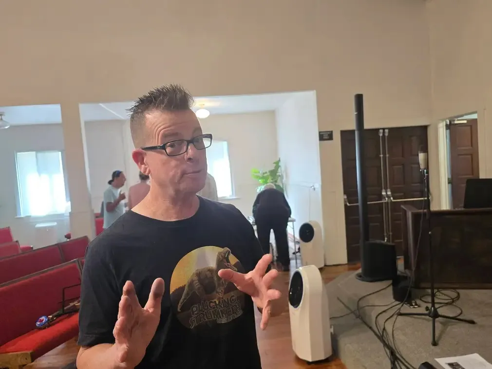 A player explaining the next song, speakers behind