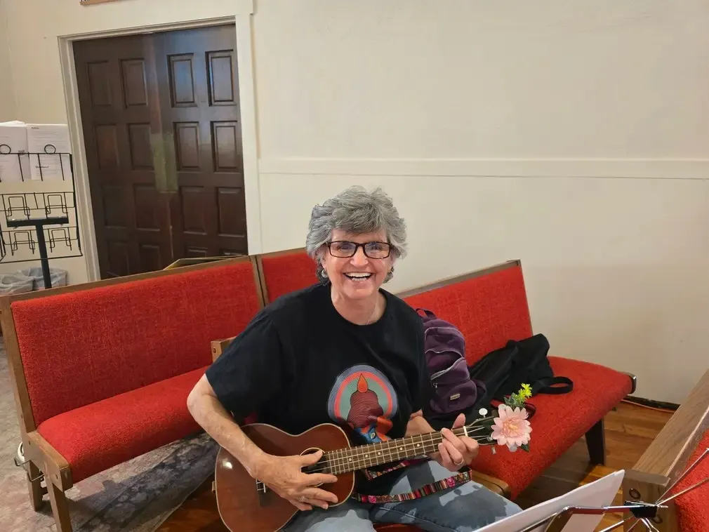 A player on the red pews with a flower on the ukulele headstock
